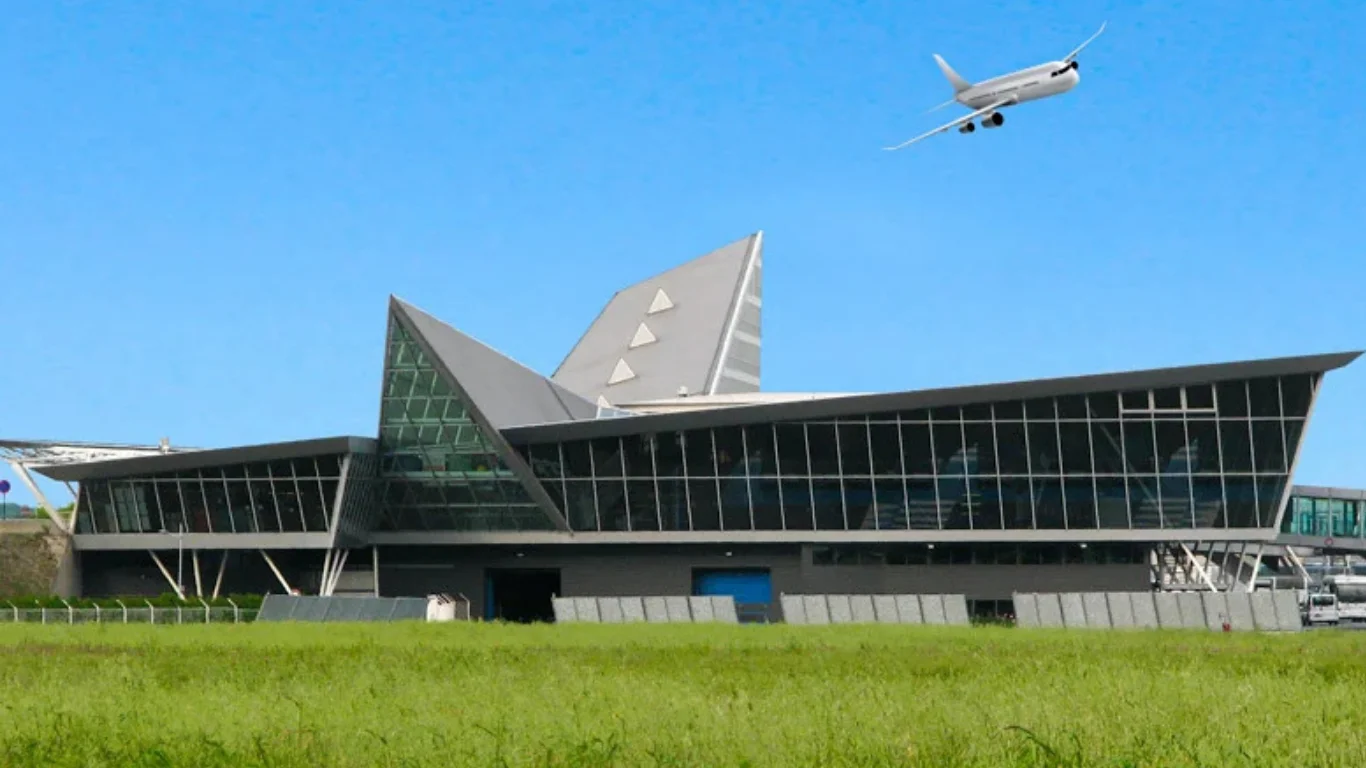 Vue de l'aérogare de l'aéroport de Lille-Lesquin (LIL) sous un ciel bleu avec un avion au décollage.